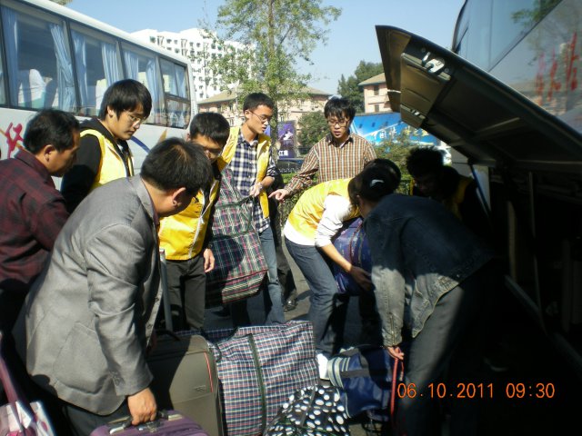 志愿者在北京西站北广场停车场装运新生行李