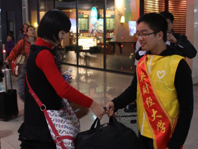 志愿者在北京南站帮助新生提行李