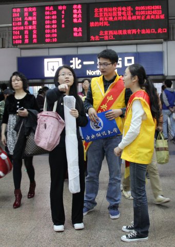 志愿者在北京西站北一出站口给新生答疑