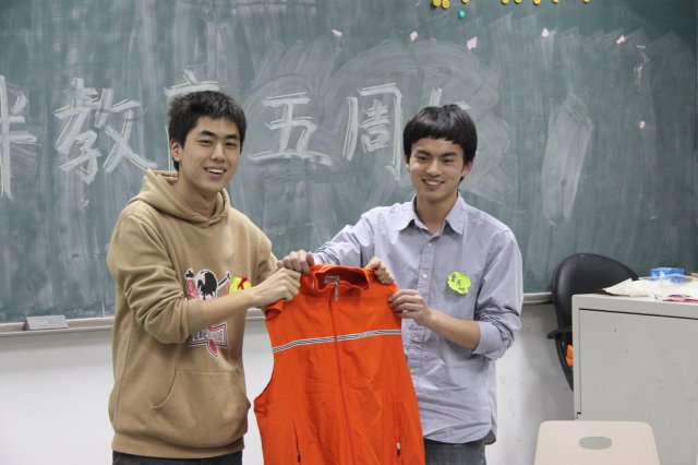 上届同伴教育负责人何旭将志愿者工作服传给曹东旭